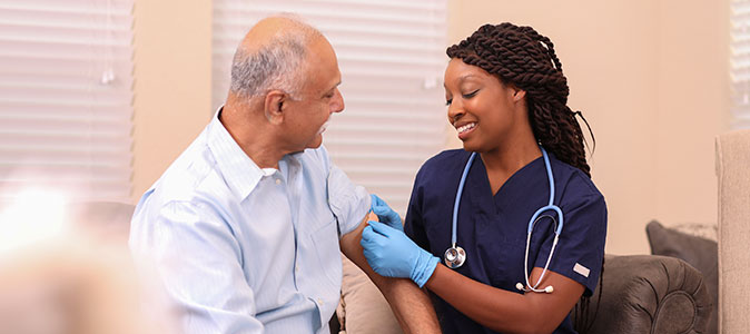 idoso se vacinando com uma enfermeira