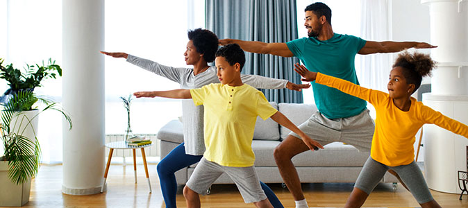 pais e filhos fazem ioga em casa