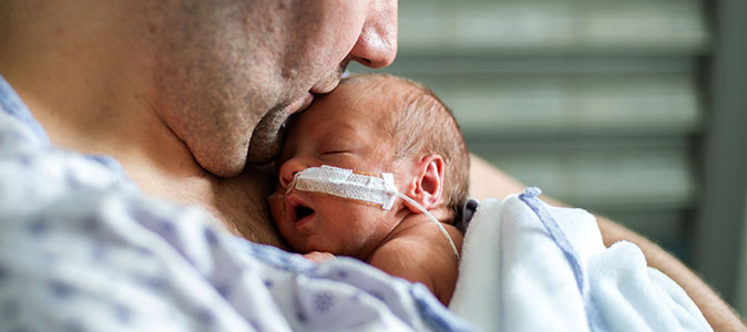 pai com um bebê prematuro no colo realiza o método canguru