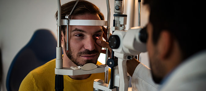 Homem realiza exame oftalmológico com médico
