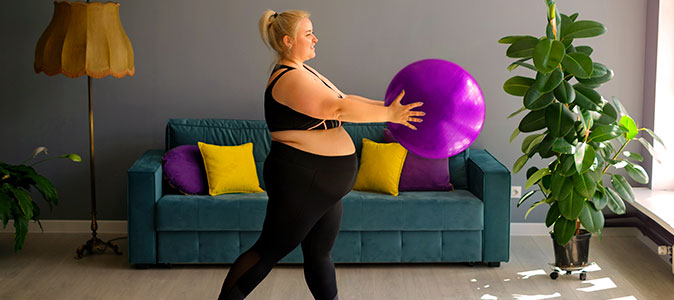 Mulher grávida se exercitando em casa