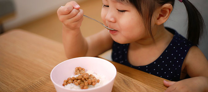 criança comendo arroz e feijão