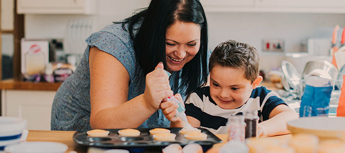 Criança ajudando a mãe a decorar cupcakes