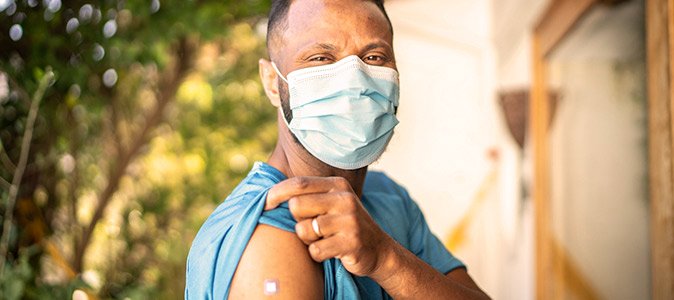 Homem mostrando curativo da vacina