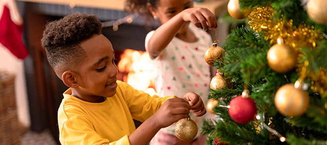 Crianças ajudando a decorar a árvore de natal