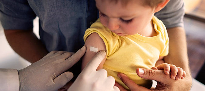 Imagem de uma criança com um bandaid no braço