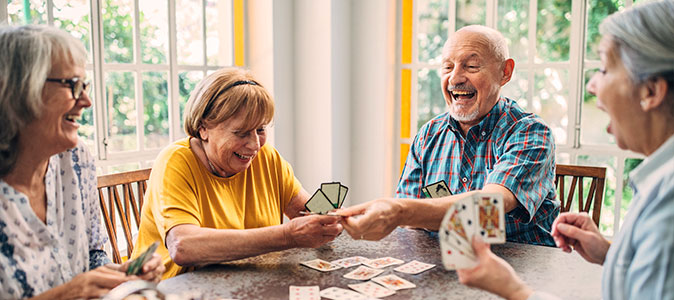 Imagem de um grupo de idosos jogando jogo de cartas